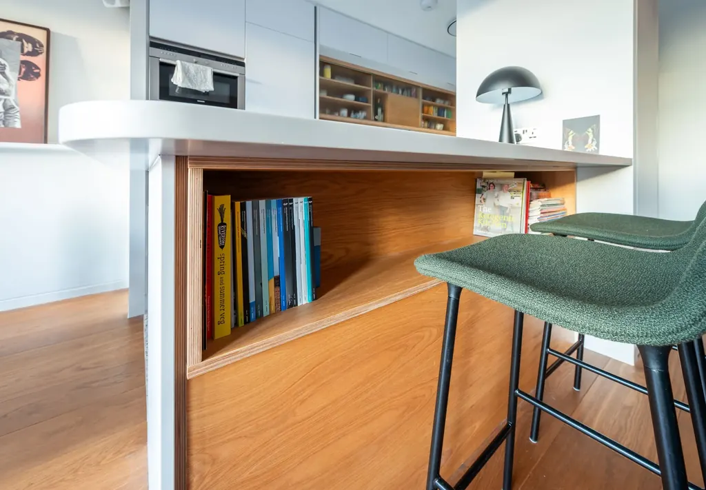 Oak-lined kitchen island with a built-in bookshelf beneath the worktop