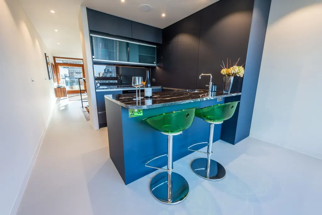 Kitchen with a deep blue island and dark worktop
