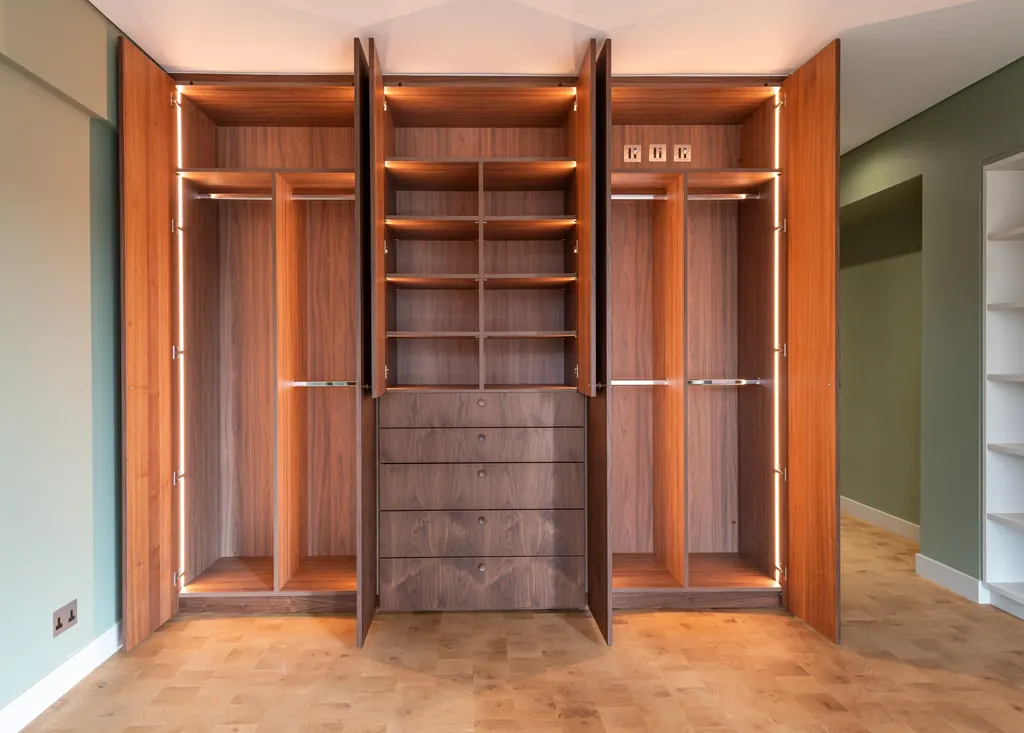 Pair of open walnut wardrobes with integrated lighting and central drawers